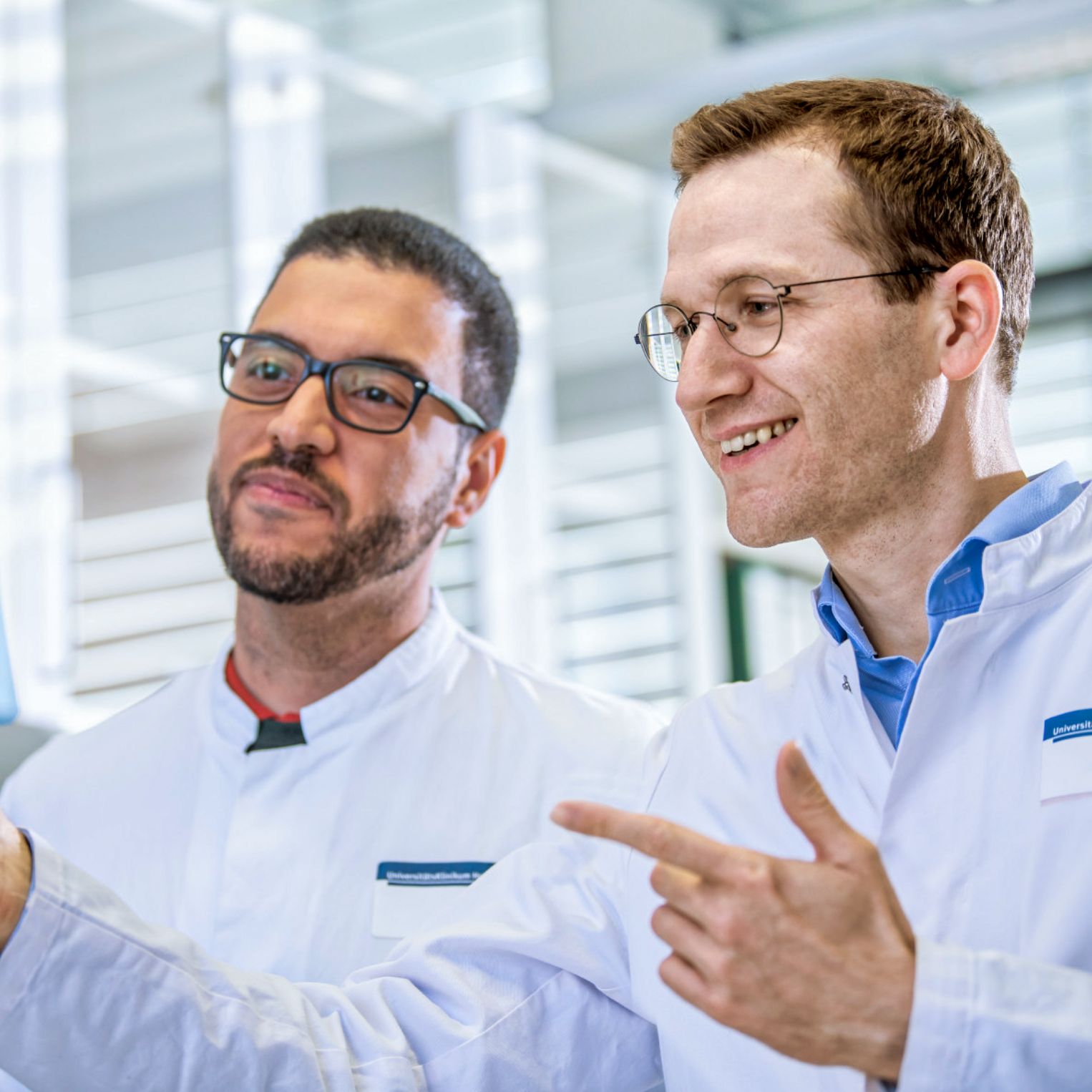 Two scientists look at a transparent sheet with lines on it.