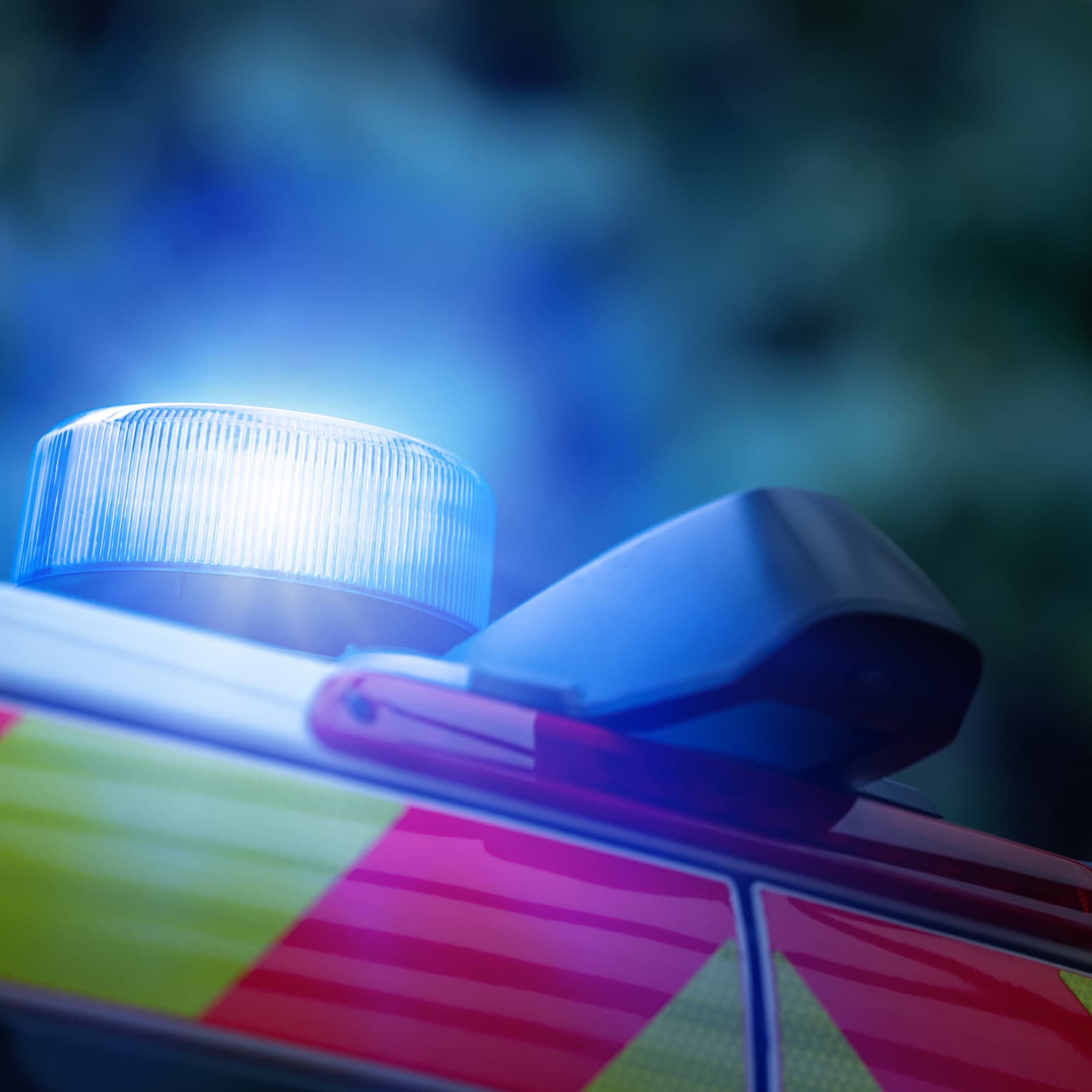 Symbolic image for emergencies: flashing blue lights on the roof of an ambulance, seen in profile.