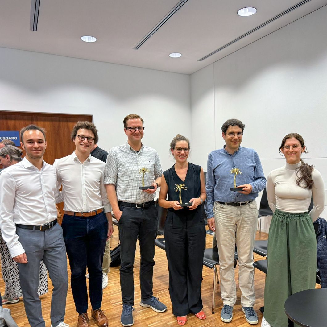 Group photo taken at the PaLMe Teaching Award ceremony: The people are standing next to each other, smiling, and the three award winners are holding a silver palm tree in their hands.