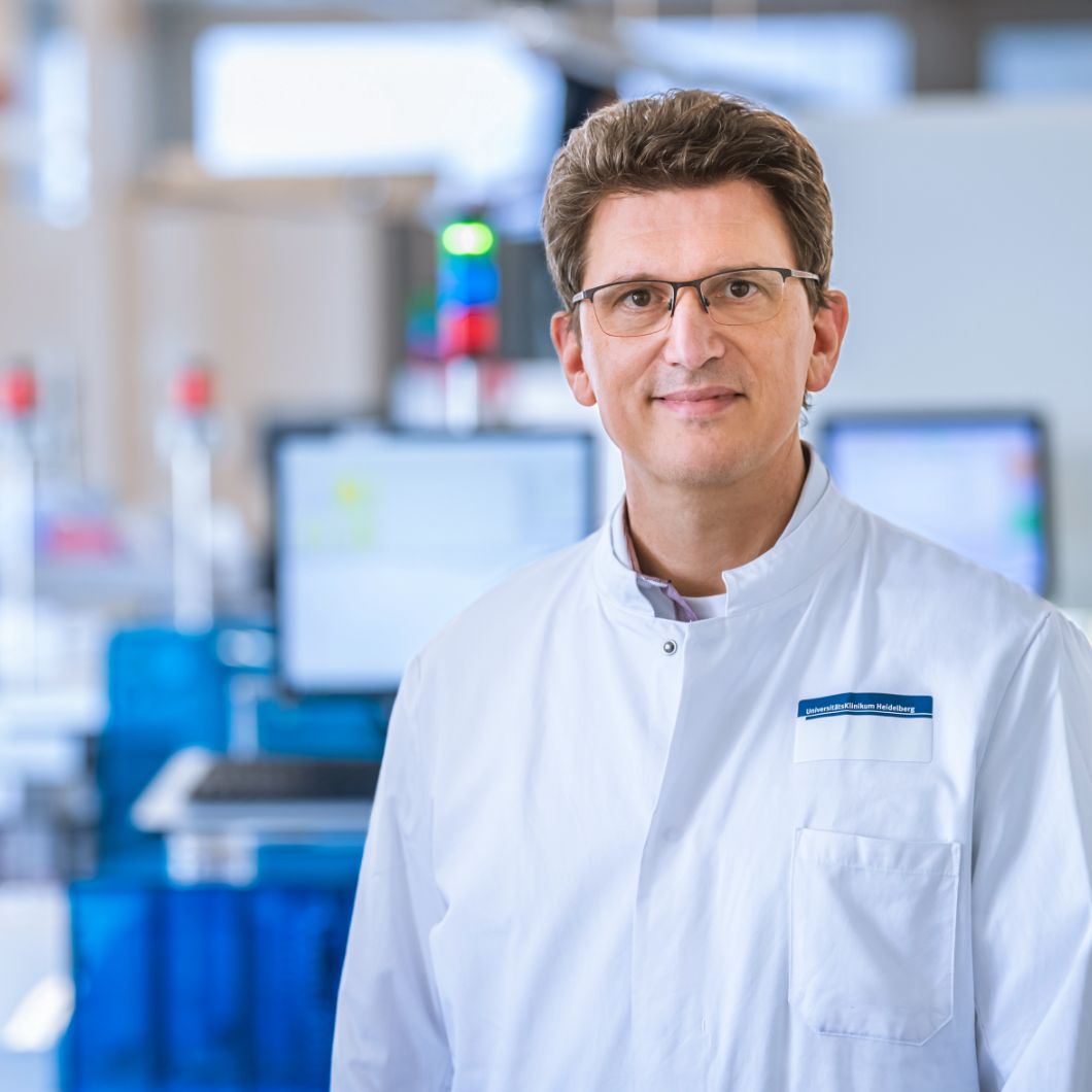 Portrait of Prof. Alexander Dalpke in a white coat in a laboratory setting