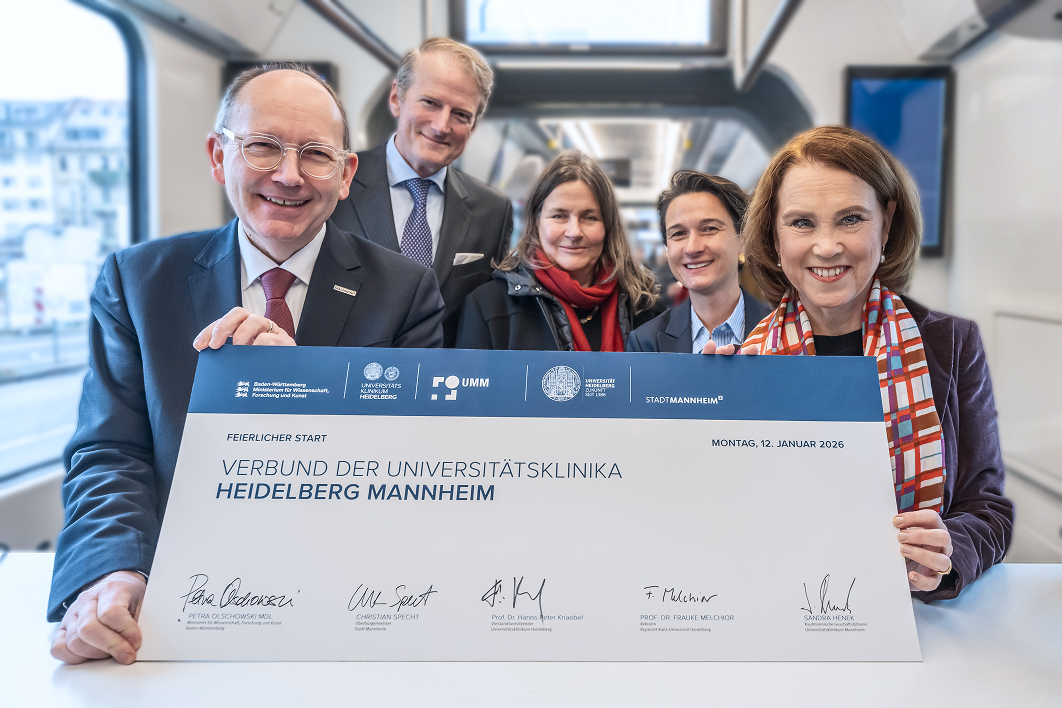 Five people present a signed agreement establishing the alliance between Heidelberg and Mannheim University Hospitals.