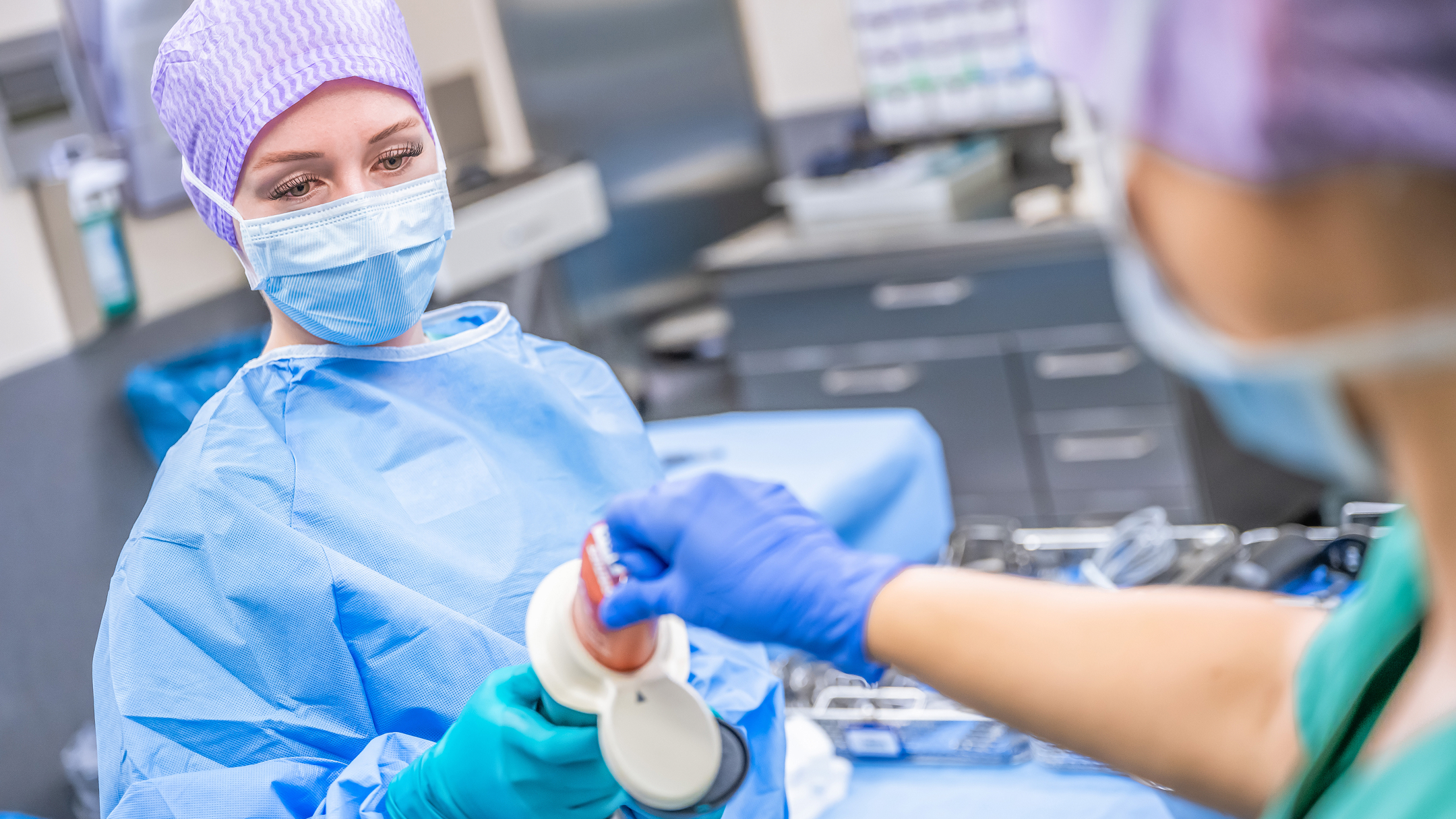 Two healthcare professionals work on a patient during an operation.